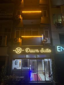 a lit up sign for a dunkin supreme restaurant at night at DUUM suite in Karşıyaka