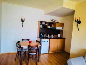 une cuisine et une salle à manger avec une table et un réfrigérateur dans l'établissement ANDALUSIA BEACH A602 Elenite, à Bourgas