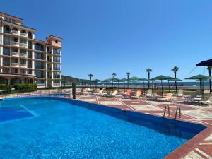 - une piscine avec des chaises et un complexe dans l'établissement ANDALUSIA BEACH A602 Elenite, à Bourgas