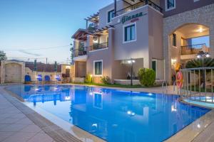 a swimming pool in front of a building at Gianna Apartments in Almirida