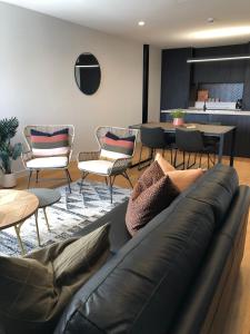 ハミルトンにあるCity Centre High End Apartmentのソファと椅子とテーブルのあるリビングルーム