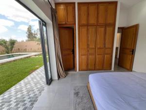 a bedroom with wooden doors and a view of a yard at Villa JADE with private pool only family in Marrakech