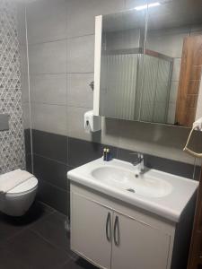 a bathroom with a white sink and a toilet at DUUM suite in Karşıyaka