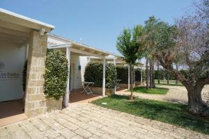 切萨雷奥港L'Ulivo e la Stella的一栋白色房子，周围绿树环绕，还有一个庭院。