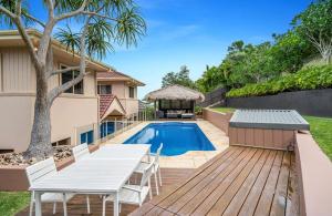 a backyard with a wooden deck and a swimming pool at Family Entertainer with Pool - Luxury Holiday House in Lennox Head in Lennox Head