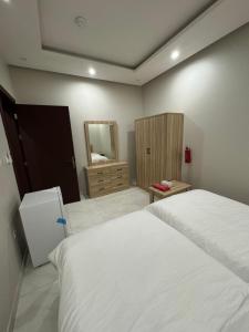 a bedroom with a white bed and a mirror at غرفة وحمام مفروشة in Riyadh