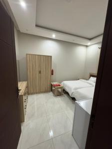 a bedroom with two beds and a tv in it at غرفة وحمام مفروشة in Riyadh