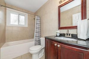 a bathroom with a sink and a toilet and a bath tub at Bungalow Home in Ottawa +21 photos