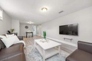 a living room with a couch and a tv on a wall at Bungalow Home in Ottawa