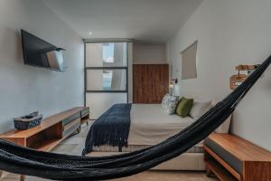 a bedroom with a hammock bed and a tv at Navela 106 Depto vista al mar in Telchac Puerto