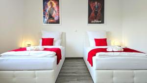two beds in a room with red and white at HAPPY HOMES FUN - Up to 8 - Küche - W-LAN - Netflix - PS5 - Badewanne in Altenstadt