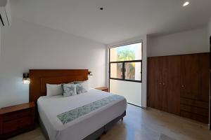 a bedroom with a large bed and a window at Navela 106 Depto vista al mar in Telchac Puerto +98 photos