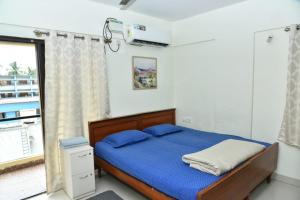 a bedroom with a bed with blue sheets and a window at 2 Bedroom Family apartment in cooke town in Bengaluru +78 photos