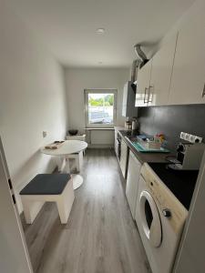 una pequeña cocina con mesa y encimera en Charming apartment near the airport, en Langenhagen