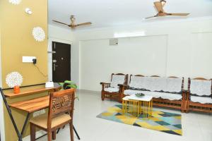 a living room with benches and a table and a rug at 2 Bedroom Family apartment in cooke town in Bengaluru