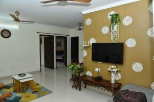 a living room with a flat screen tv on a wall at 2 Bedroom Family apartment in cooke town in Bengaluru