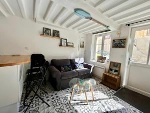 a living room with a couch and a table at Charmante maison au coeur de Villerville in Villerville