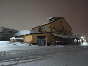 a building with snow on the ground in front of it at El Puente dptos in Caviahue
