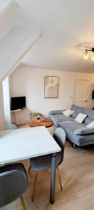 a room with two beds and a table and chairs at Le Rochois T2 38m2 in La Roche-Derrien