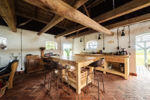 a kitchen with a wooden table and bar stools at Sielskie Siedlisko w Czerwonym Dworze in Węgorzewo