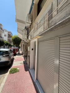 a sidewalk next to a building with a garage at Cosy Apartment on Mpoleti in Loutraki