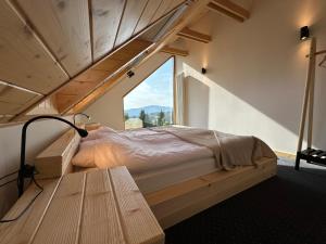 a bedroom with a bed and a large window at ŻŁOBINA Dom in Wisła