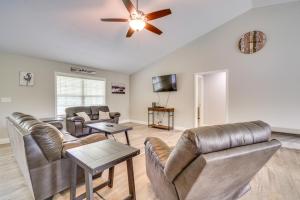 a living room with leather furniture and a ceiling fan at Wraparound Porch Home Near Dtwn Crossville! in Crossville