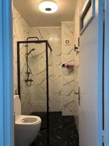 a bathroom with a toilet and a walk in shower at Appartement fraîchement rénové in Oualidia
