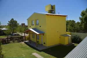 a small yellow house with a roof at Dunas Norte Departamentos in Balneario El Condor