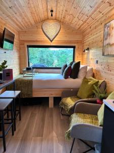 a room with a bed and a large window at River Huts with Private Hot Tubs in Inverness