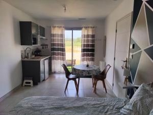 a kitchen and dining room with a table and chairs at Studio cosy proche des vignes in Roubia