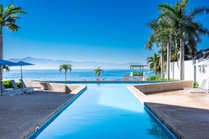a swimming pool with the ocean in the background at Zantamar PH608B, frente al mar in Cruz de Huanacaxtle