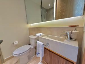 a bathroom with a toilet and a sink and a mirror at Zantamar PH608B, frente al mar in Cruz de Huanacaxtle