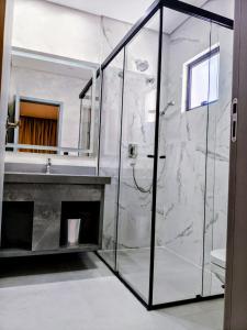 a bathroom with a glass shower and a sink at Pousada Big Bear II in Campos do Jordão