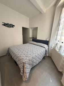 a bedroom with a bed with a blanket on it at Casa Giulé in Imperia