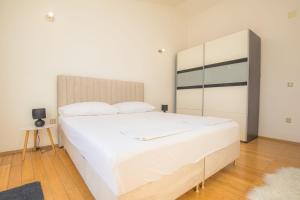 a bedroom with a large white bed and a mirror at House Matilda in Primošten +39 photos