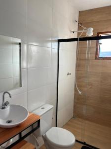 a bathroom with a toilet and a sink and a shower at Pousada Mundo Mágico in São Thomé das Letras