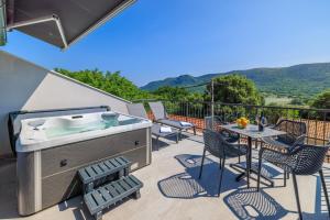 a hot tub on a patio with a table and chairs at House Maris in Tribalj
