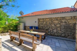 a wooden table and two benches on a patio at House Maris in Tribalj