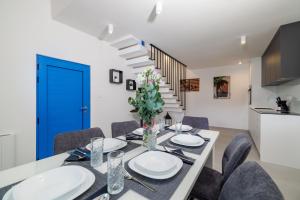 a dining room with a table and chairs and a blue door at House Maris in Tribalj