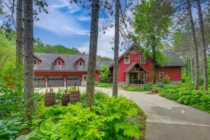 a red house in the middle of a forest at Hot Tub and Private Sauna Wausau Family Home in Wausau