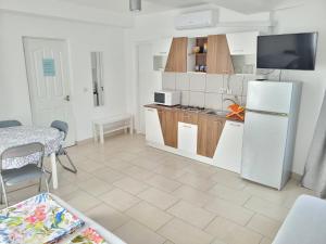 a kitchen with a white refrigerator and a table at Vila Toscana in Eforie Nord