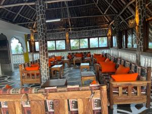 ムトワッパにあるMama Africa Villageの木製の椅子とテーブル、窓のあるレストラン