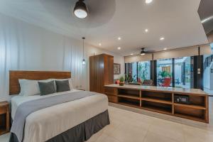 a bedroom with a large bed and a desk at Casa Regina Loft Paseo de Montejo in Mérida