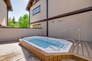 a jacuzzi tub sitting on the deck of a house at Walk to Main Street Hot Tub Gym and Game Room in Breckenridge