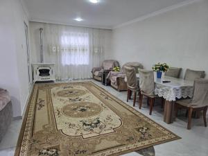 a living room with a table and a rug at Guba House Near Forest & Lake in Quba