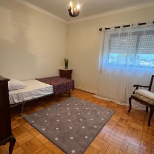 a room with a bed and a chair and a window at Casa de férias in Monte