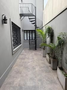 a hallway with plants and a staircase in a building at El departamentito in Yerba Buena