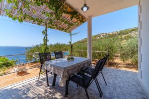 a table and chairs on a patio with a view of the ocean at Korak Do Mora in Murvica