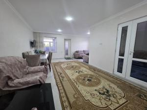 a living room with a couch and chairs and a rug at Guba House Near Forest & Lake in Quba